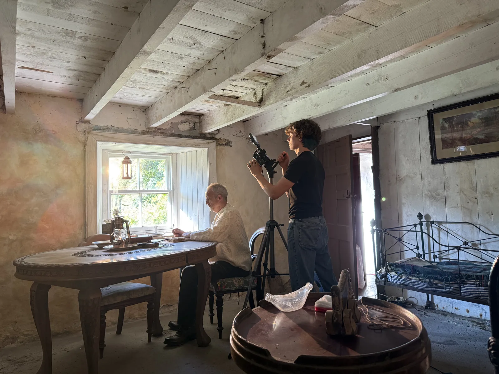 Dreh in einem alten Cottage: Luis filmt vom Stativ, Stephen Corrall sitzt am Tisch vor dem Fenster