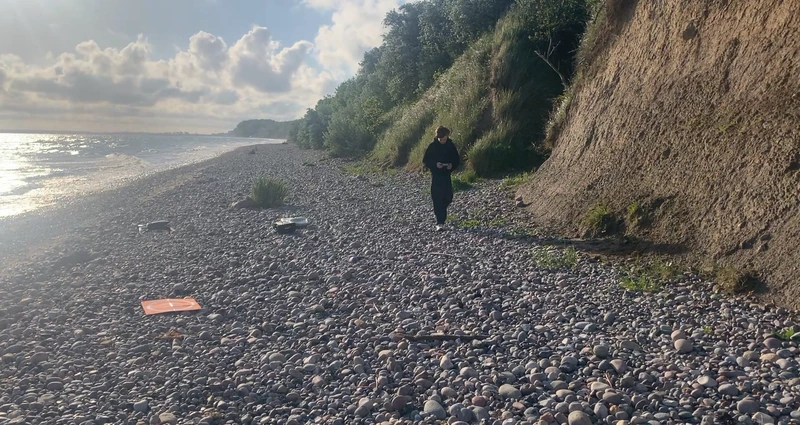 Luis an einem Steinstrand unter einer Steilküste