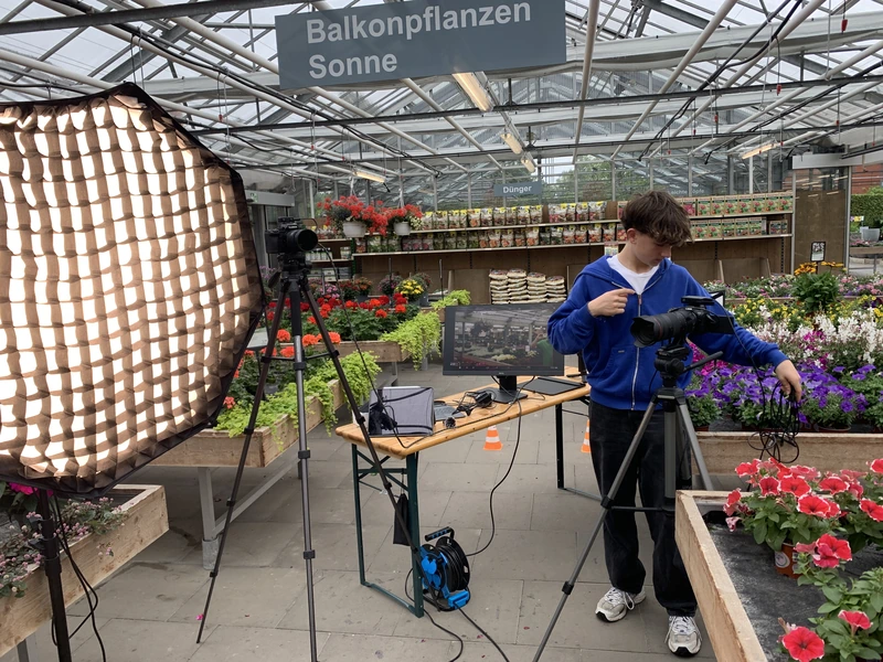 Luis an der Kamera, daneben eine große Softbox zwischen Balkonpflanzen
