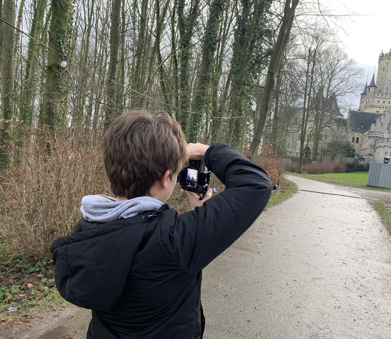 Luis fotografiert auf einem Weg zwischen kahlen Bäumen